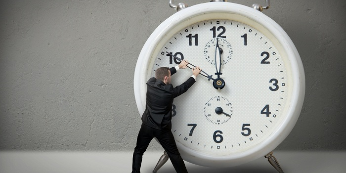 Businessman Pulling A Clock Hand Backwards